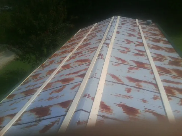 Rusted metal roof panels with new wood purlins before replacement — Storm Damage Roof Repair in Riga by Roofing Brothers