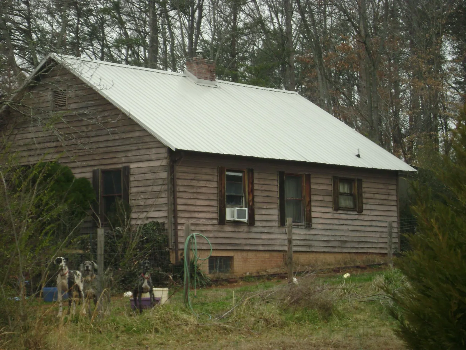 White metal roof on an old wood sided farmhouse, from a Metal Roof Installation job in Riga